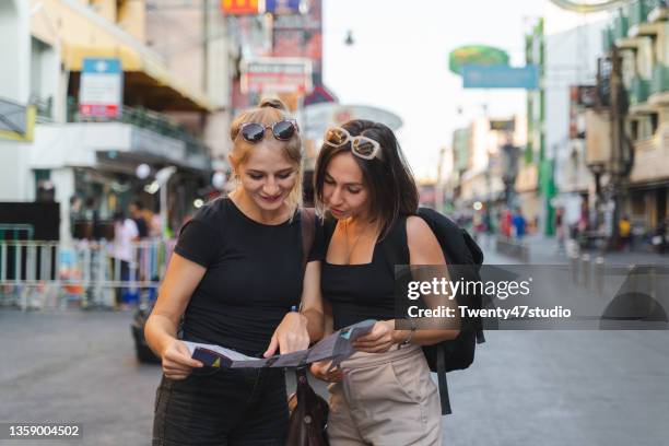 two caucasian females enjoy travel in khao san road in bangkok - bangkok business stock pictures, royalty-free photos & images