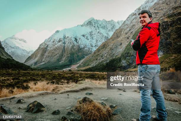 tourist man with his back facing the camera in the middle of the new zealand mountain - facing camera professional outdoor stockfoto's en -beelden