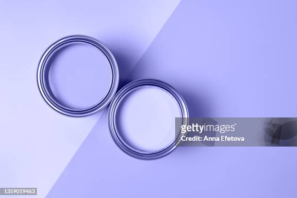 two open cans with pastel violet paints arranged on background divided in two parts. performed flat lay style with copy space. concept of redecoration in home interior. demonstrating very peri - color of 2022 year. - pastel colored stock-fotos und bilder