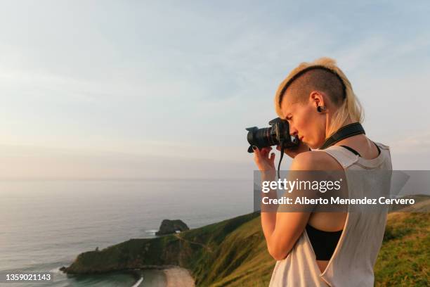 young woman taking sunset pictures - 写真家 ストックフォトと画像