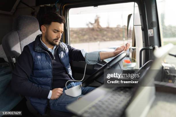 truck driver sitting in cabin and measuring blood pressure - cinema society screening of you will meet a tall dark stranger arrivals stockfoto's en -beelden