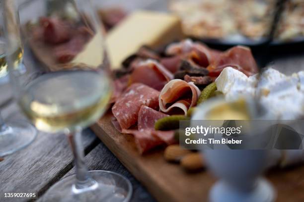 sliced charcuterie meat and cheese on a cutting boar. - charcuterie stockfoto's en -beelden