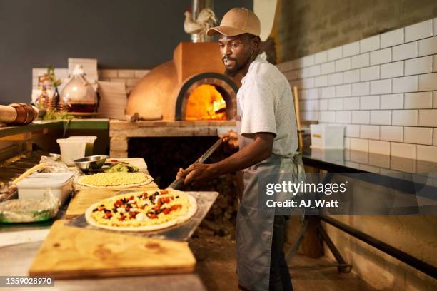 伝統的なピザを準備するレストランのキッチンで働く男 - pizzeria ストックフォトと画像