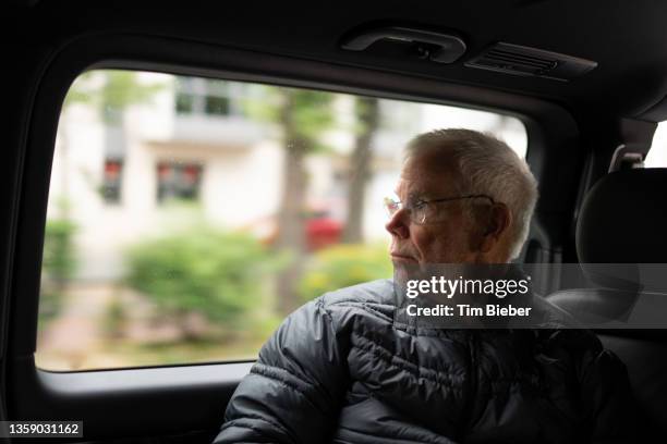 man riding in vehicle looking out window. - trasporti funebri foto e immagini stock