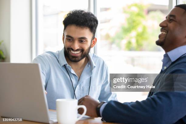 two men looking at laptop in meeting - web design stock pictures, royalty-free photos & images