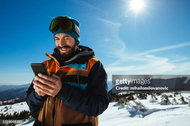 trouver du temps pour ses médias sociaux - sport d'hiver photos et images de collection