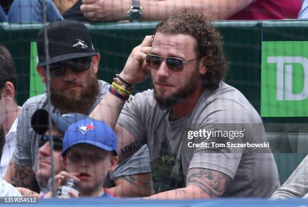 Players Jonny Gomes and Jarrod Saltalamacchia of the Boston Red Sox watch the Toronto Blue Jays MLB game against the Oakland Athletics before their...