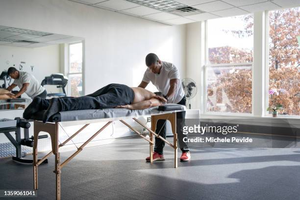 male professional performing massage on a client - masseuse stock pictures, royalty-free photos & images