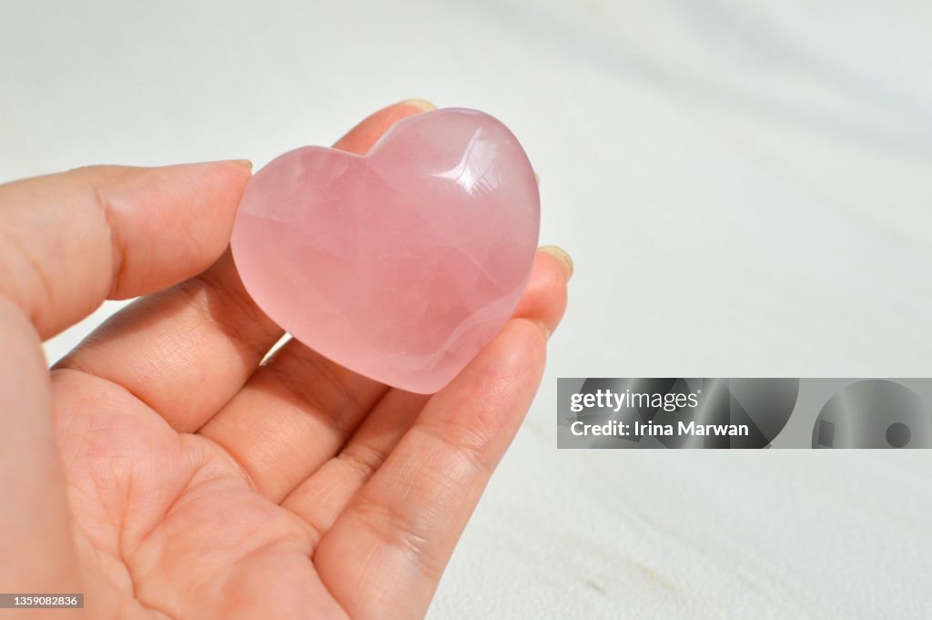 Woman Holding a Rose Quartz Crystal Heart