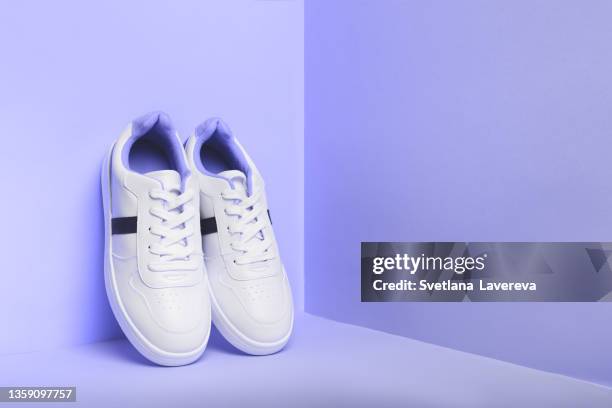 white sport sneakers shoes on the violet background. fitness background. - blue shoe foto e immagini stock