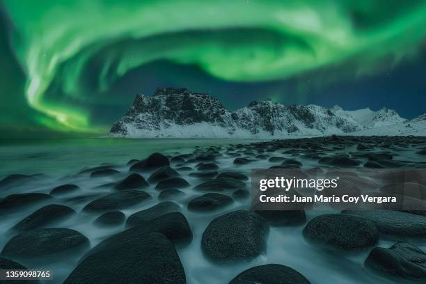 the dance of the green lady, uttakleiv beach, lofoten islands, nordland, northern norway, norway - aurora borealis lofoten stock-fotos und bilder