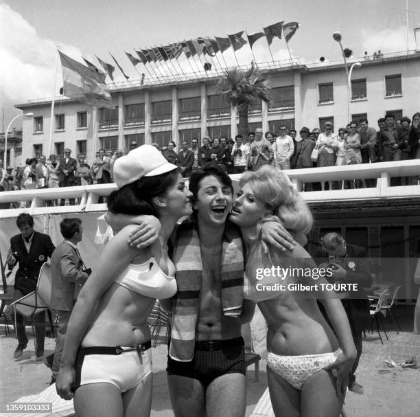 Hervé Vilard en compagnie de deux jeunes femmes lors du Festival de Cannes en mai 1966