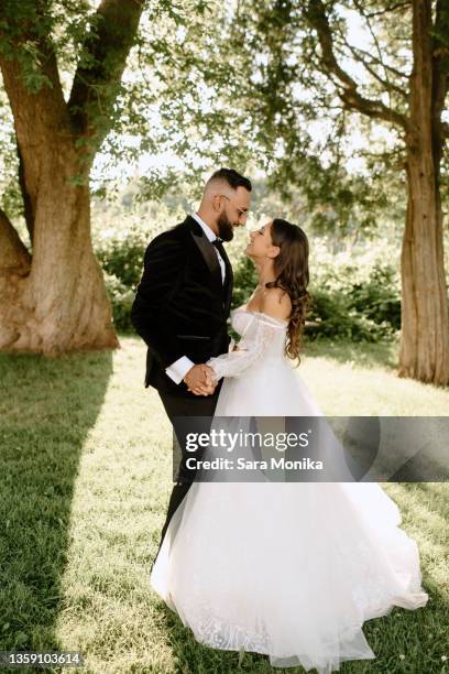 bride and groom in park - newlywed fotografías e imágenes de stock