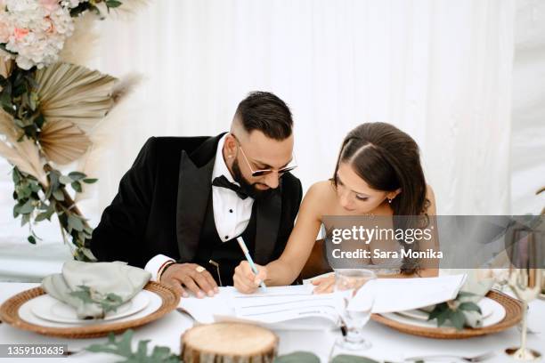 bride and groom signing their marriage certificate - marriage certificate stock pictures, royalty-free photos & images