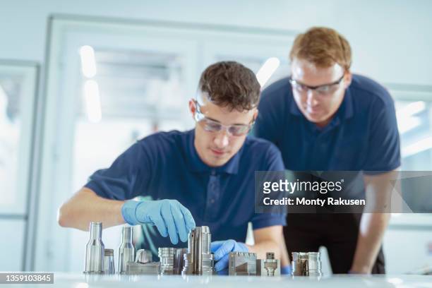 engineerêguiding trainee in laboratory - blue glove stock pictures, royalty-free photos & images