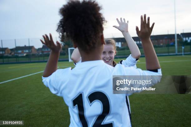 uk, female soccer team members giving high five in field - sporting term stock pictures, royalty-free photos & images