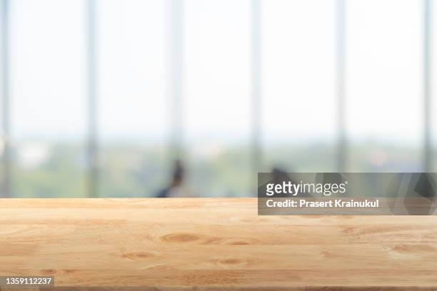 empty wood table top, counter, desk background with blurred window background - desk stock-fotos und bilder