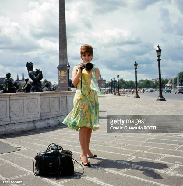 Gina Lollobrigida sur la Place de La Concorde à Paris avec son appareil photo en juillet 1965