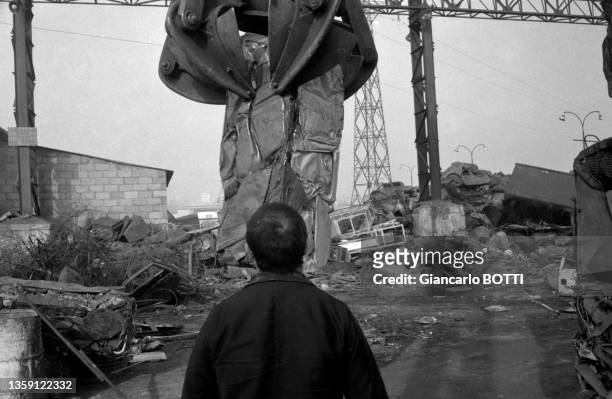 Le sculpteur César Baldaccini choisit des carcasses de voitures dans une casse automobile en banlieue parisienne le 16 février 1961