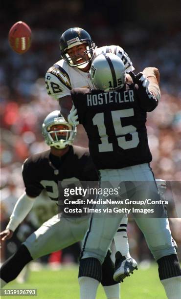 Raider QB Jeff Hostetler barely gets rid of the ball in time as Charger CB Dwayne Harper bears down on him late in the 2nd quarter on Sunday August...