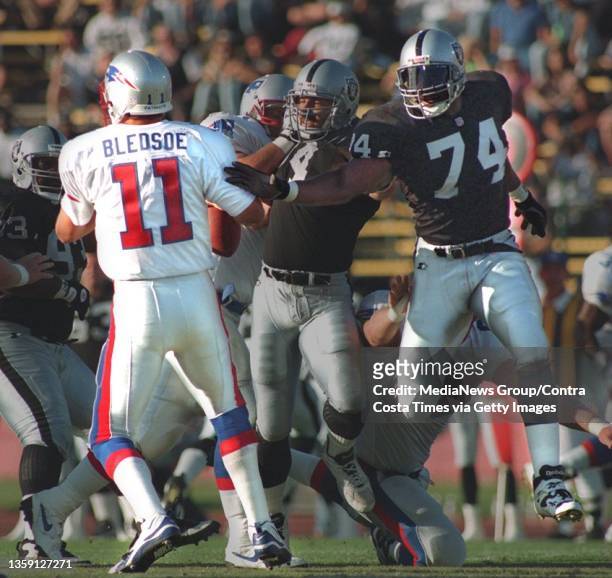 Nolan Harrison of the Oakland Raiders, , #74, grabs Drew Bledsoe's, #11, , arm on August 25, 1995 at the Oakland Coliseum. 1995