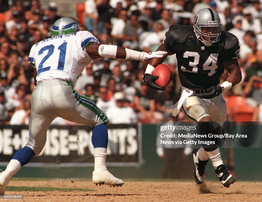 Derrick Fenner of the Oakland Raiders, right, attempts to run the News  Photo - Getty Images