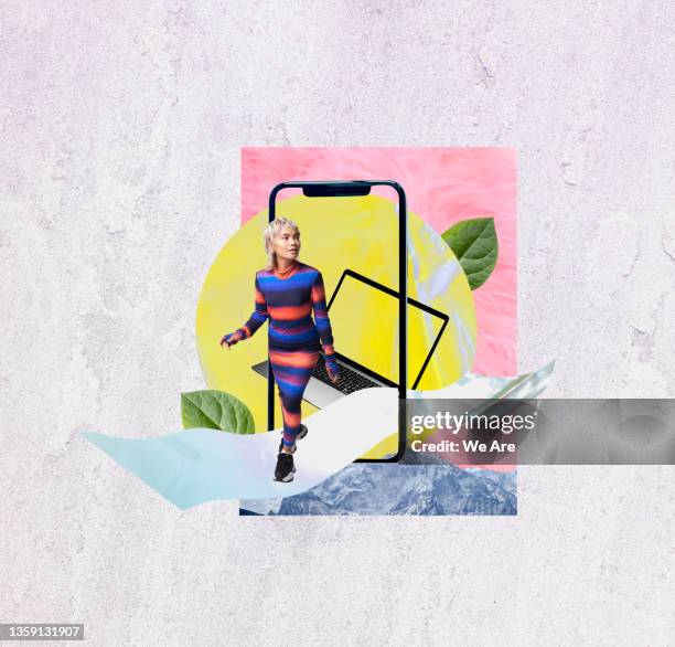 young fashionable woman stepping out of smartphone into open space - escapisme stockfoto's en -beelden