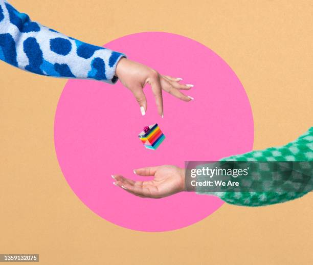 woman dropping gift into outstretched hand - happy moment woman photos et images de collection