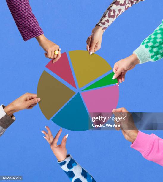 hands removing sections of pie from pie chart - community diversity stockfoto's en -beelden