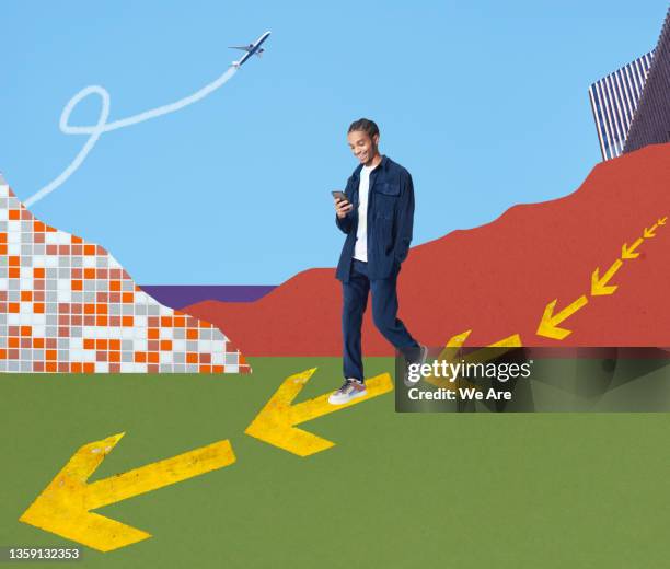 young fashionable man walking on arrows using smartphone - quitting a job stockfoto's en -beelden