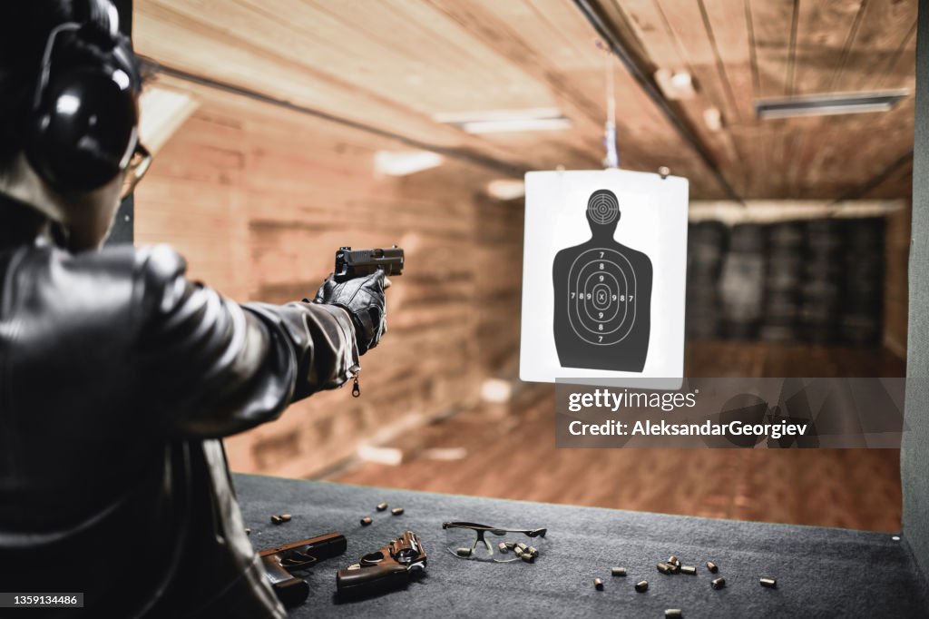 範囲上の銃を持つ現代の男性によるクローズターゲット高速射撃練習