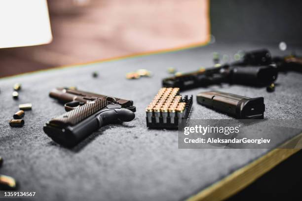 schusswaffen, magazine und patronen auf dem schießstandtisch - feuerwaffen abzug stock-fotos und bilder