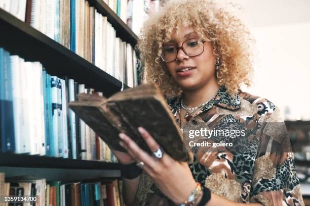 young woman reading in old book in library - old book 個照片及圖片檔