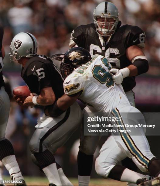 Raiders guard PHOTO BY MERI SIMON Kevin Gogan grabs Jacksonville's DE Tony Brakens who has a hold on Raiders QB Jeff Hostetlert in the second...