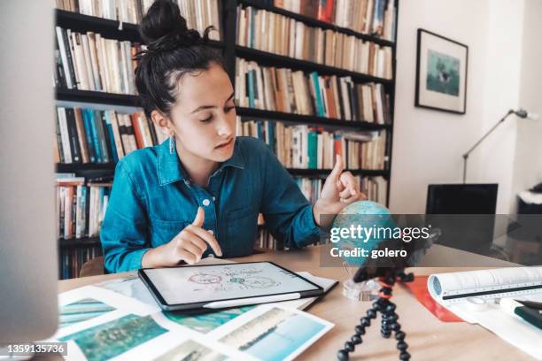 une adolescente prépare une présentation pour les problèmes de changement climatique sur tablette numérique et globe - high school student photos et images de collection