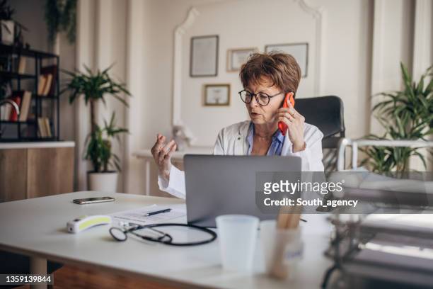 female doctor in her office - desk phone stock pictures, royalty-free photos & images
