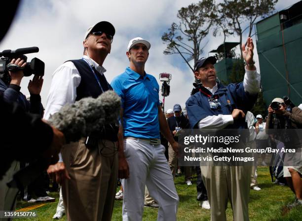 Dustin Johnson, center, talks with rules officials after being unable to find his drive on the third hole after five minutes during the fourth round...