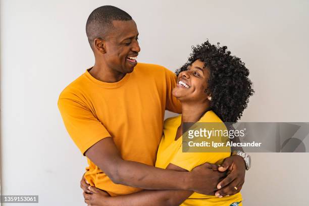 un couple afro-américain s’étreignant - couple sourire studio photos et images de collection