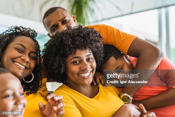 retrato de una familia unida mirando a la cámara - fond orange fotografías e imágenes de stock