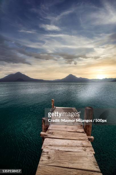 atitln lake,woman on pier over sea against sky during sunset,panajachel,guatemala - panajachel stock pictures, royalty-free photos & images