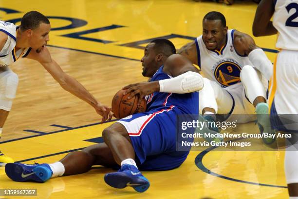 Los Angeles Clippers' Glen Davis struggles for the ball against Golden State Warriors' Stephen Curry and Andre Iguodala during the first half of the...