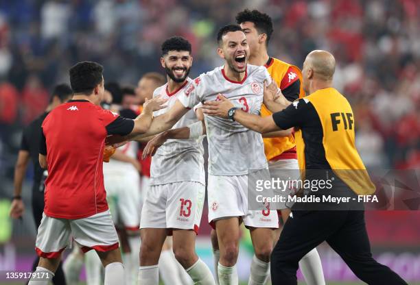 Ferjani Sassi, Montassar Talbi and teammates of Tunisia celebrate following victory during the FIFA Arab Cup Qatar 2021 Semi-Final match between...