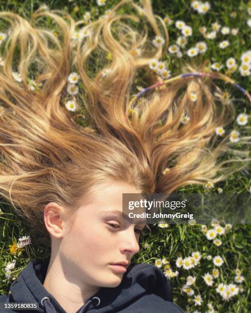 girl lying down among daisies in the grass - girl lying down stock pictures, royalty-free photos & images