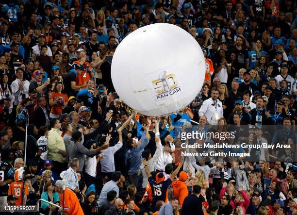 Football fans play with a large inflated ball during the Denver Broncos game against the Carolina Panthers in Super Bowl 50 at Levi's Stadium in...