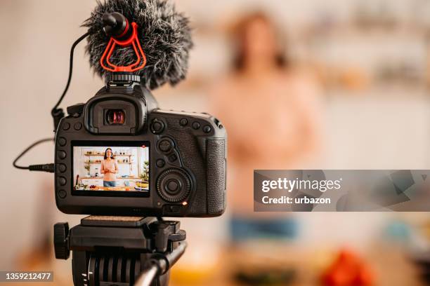 yong donna che registra video vlog cucinare cibo sano - content foto e immagini stock