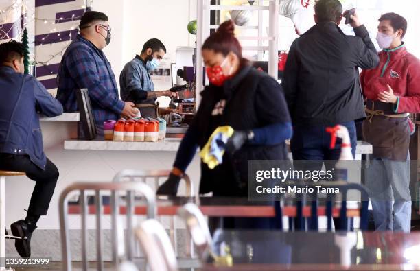 People wear face coverings inside Grand Central Market on December 15, 2021 in Los Angeles, California. California residents, regardless of COVID-19...