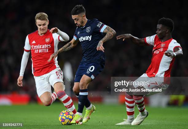 Manuel Lanzini of West Ham United takes on Martin Odegaard and Bukayo Saka of Arsenal during the Premier League match between Arsenal and West Ham...