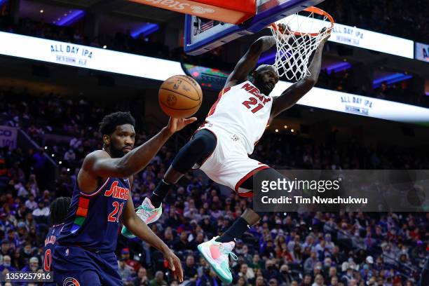 Dewayne Dedmon of the Miami Heat dunks past Joel Embiid of the Philadelphia 76ers during the third quarter at Wells Fargo Center on December 15, 2021...
