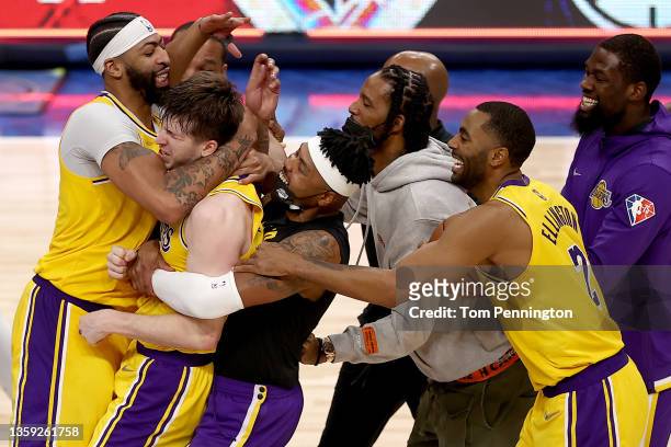 Austin Reaves of the Los Angeles Lakers reacts after shooting the game-winning shot against Tim Hardaway Jr. #11 of the Dallas Mavericks in overtime...