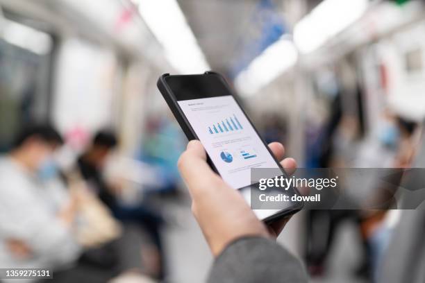 young man using mobile phone on subway - metro screen door stockfoto's en -beelden